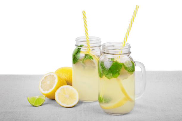 istock Freshly and multi-colored drinks with ripe, juicy and fresh lemons, bright green mint, water on a light fabric, isolated on a white background. Summer drinks - cold lemonade. 814697906