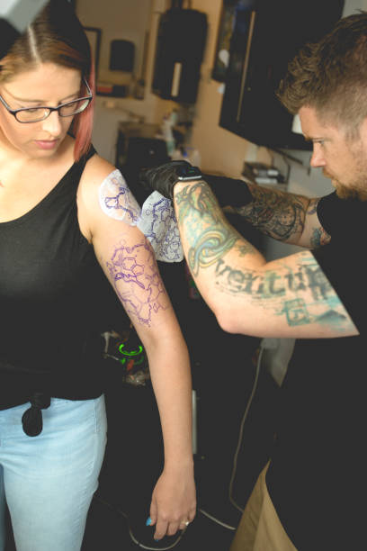 istock Tattoo Artist Peeling Away a Stencil from Customer 814706014