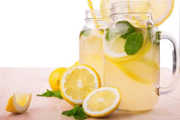 istock Refreshing and multi-colored drinks with ripe, juicy and fresh lemons, bright green mint and mineral water on a light wooden table, isolated on a white background. 814706072