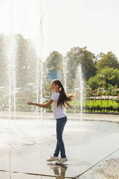 istock Two happy kids playing in fountain 814727874