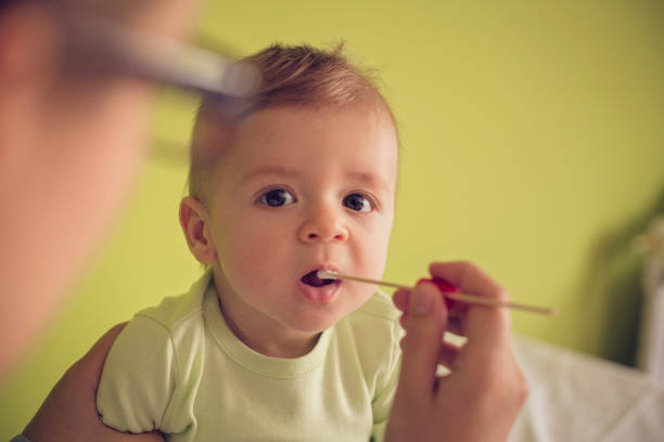 Doctor taking medical sample from baby Doctor taking medical sample from baby mouth with cotton swab medical swab stock pictures, royalty-free photos & images