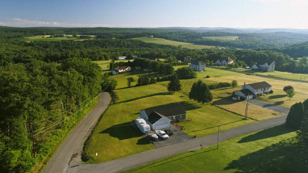 The scenery aerial view of Poconos, Monroe County, Pennsylvania. The sunny summer morning. The panoramic overview over the field and forest to the Kunkletown, then to the small farm near by the road. The scenery aerial view of Poconos, Monroe County, Pennsylvania, USA. 4K UHD drone video footage. The sunny summer morning. the poconos stock pictures, royalty-free photos & images