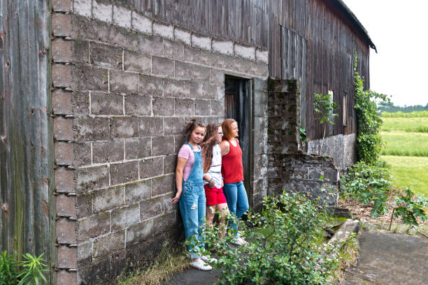 istock Girls Leaning Against Brickwall of Old Barn 814761580