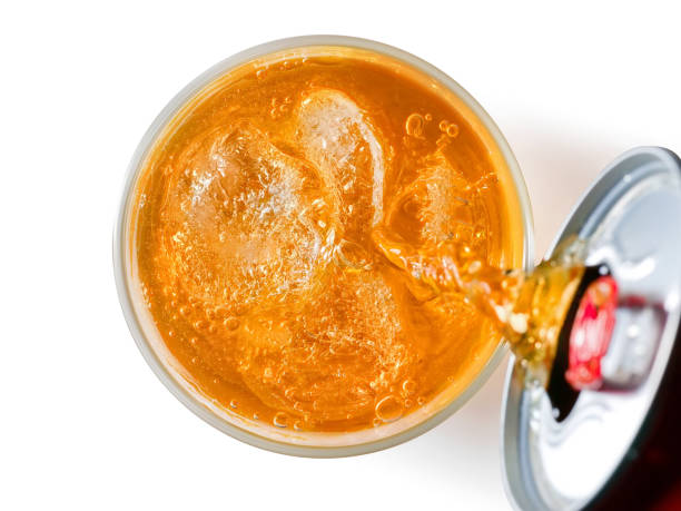 Orange soft drink liquid pouring from a can into a glass. Top view Orange soft drink liquid pouring from a can into a glass. Top view. Isolated on white, clipping path included above can drink high angle view stock pictures, royalty-free photos & images