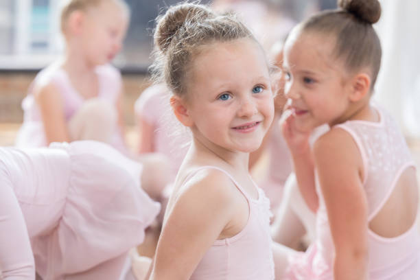 istock Young ballerina turns to listen to instructor during a class break 814797040