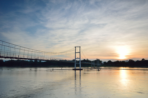 夕日と川を渡る古い懸濁液の歩道橋。 - ストックフォト・写真素材...