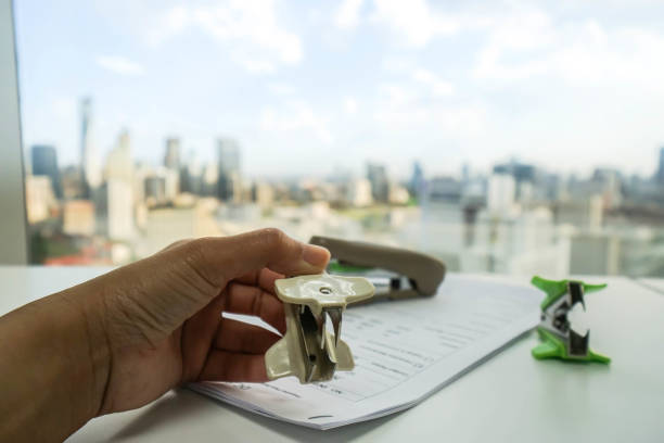 istock business women hold white staple remover on office documents 814889742