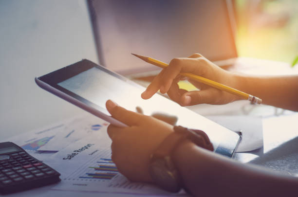 istock Businessman holding Tablet and working with laptop on the table and analyzing investment chart working in office. Business work concept. 814911542