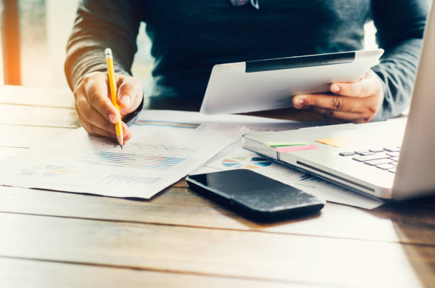 istock Businessman holding Tablet and working with laptop on the table and analyzing investment chart working in office. Business work concept. 814912128