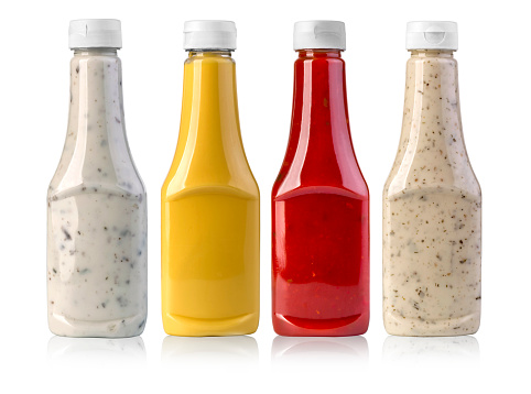 barbecue sauces in glass bottles on white background
