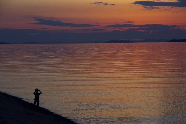 istock boy taking a photo of sunset 814931490
