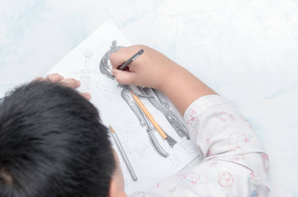 school boy drawing picture with color pencil, education concept.