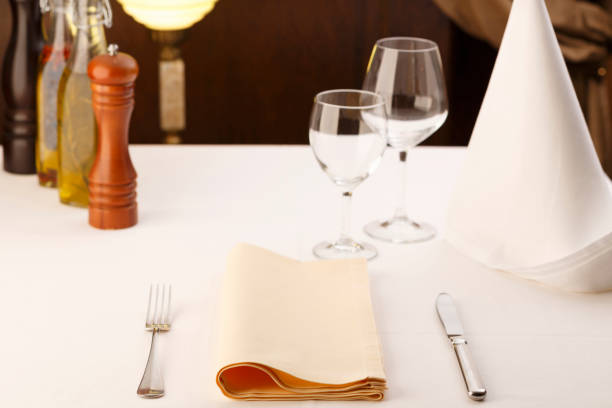 istock Fork and table knife with napkin arranged in elegant setting, Wineglass in the background, Selective focus with soft light 814957116