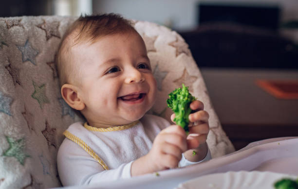 istock Baby boy eating broccoli 814962272