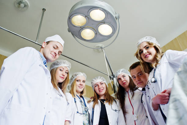 istock Confident and talented surgeons gathered around surgical light in the operating room. 814963198