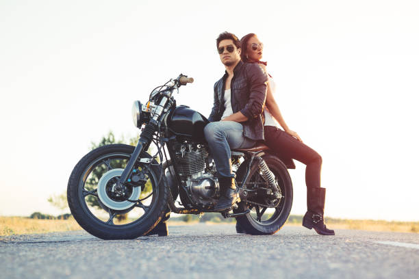 Man and woman, motorcycle riders, enjoys together in nature