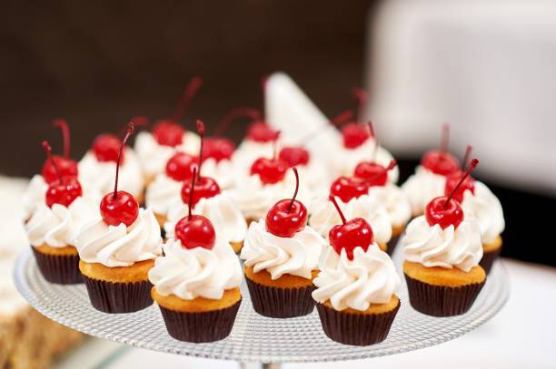 istock Plate full of cupcakes with cream and cherry on top 814985374