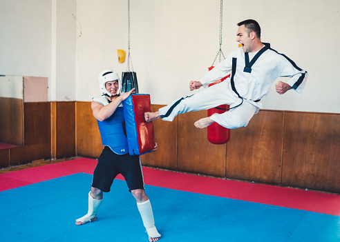 Sportsmen training taekwondo at the fighting ring