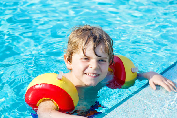 istock Happy little kid boy having fun in an swimming pool 814989176