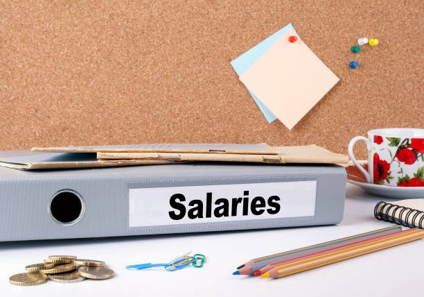 istock Salaries. Folder and a coffee mug on a white table 814992752