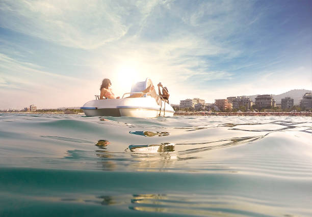 две молодые женщины отдыхают на педаль лодке - pedal boat стоковые фото и изображения