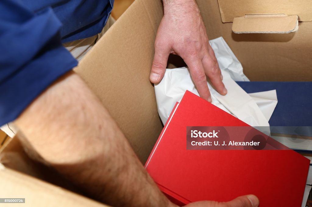 Laying books into a moving box Laying books into a moving box, close up Germany Stock Photo