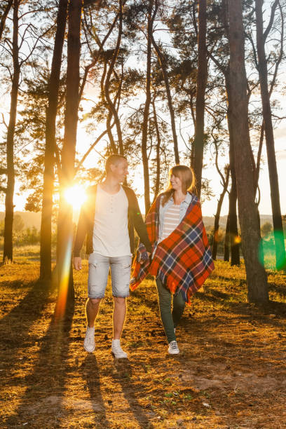 istock young loving couple walking in the park 815001202