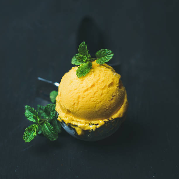 istock Refreshing Mango sorbet ice-cream scoop in scooper, square crop 815004820