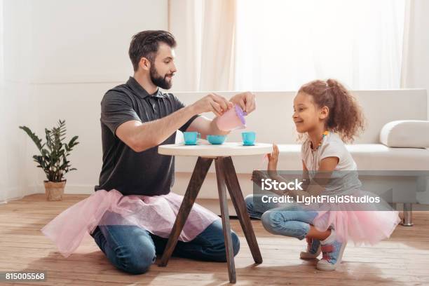 Multicultural Father And Little Daughter Having Tea Party At Home Stock Photo - Download Image Now
