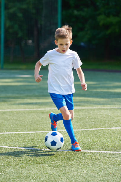 istock Boy soccer player running with ball 815012192