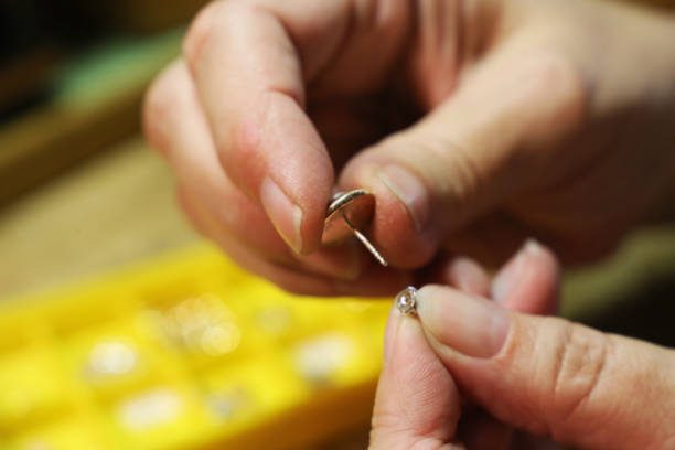 istock Female goldsmith repairing an earring 815012322