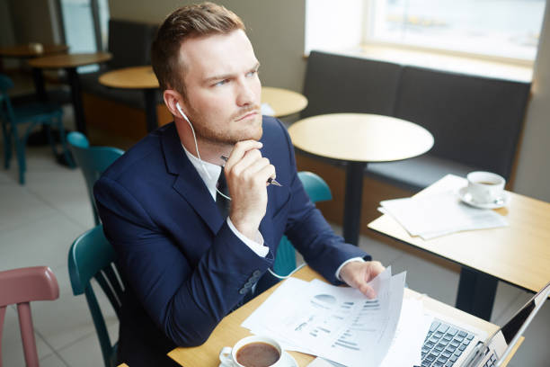 istock Young man with papers concentrating on financial analysis 815039524
