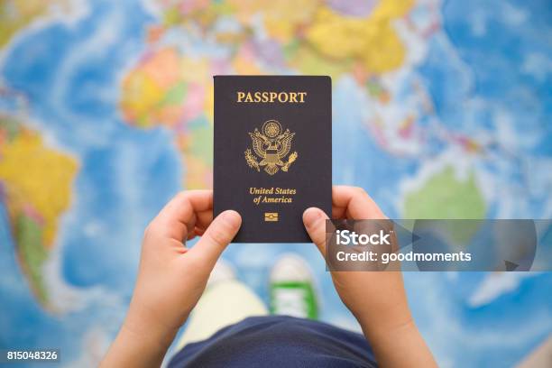 Childs Hand Holding Us Passport Map Background Ready For Traveling Open World Stock Photo - Download Image Now