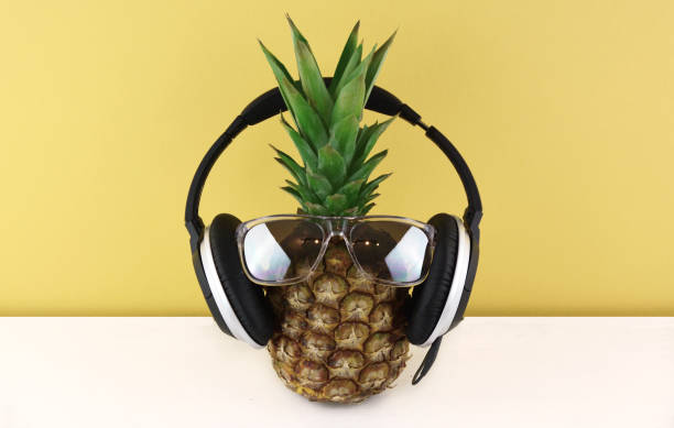 istock Ripe pineapple wearing sunglasses on yellow background. 815058874
