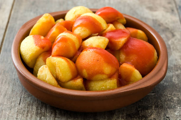 Patatas bravas Patatas bravas in bowl on wooden background patatas bravas stock pictures, royalty-free photos & images