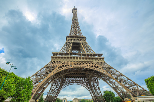 Prospective view of Tour Eiffel, symbol and icon of Paris. Paris Eiffel Tower lower panorama from bottom in Champ de Mars garden, from Paris in France. Europe travel concept.