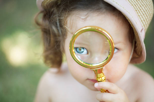 Pretty girl looking through magnifier