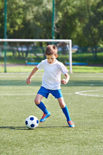 istock Boy soccer player running with ball 815082154