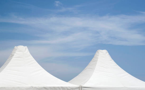 istock Top of white canvas tent on cloudy sky 815085208