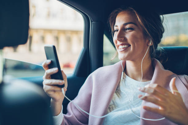 携帯電話の車の中で幸せな女 - high society audio ストックフォトと画像