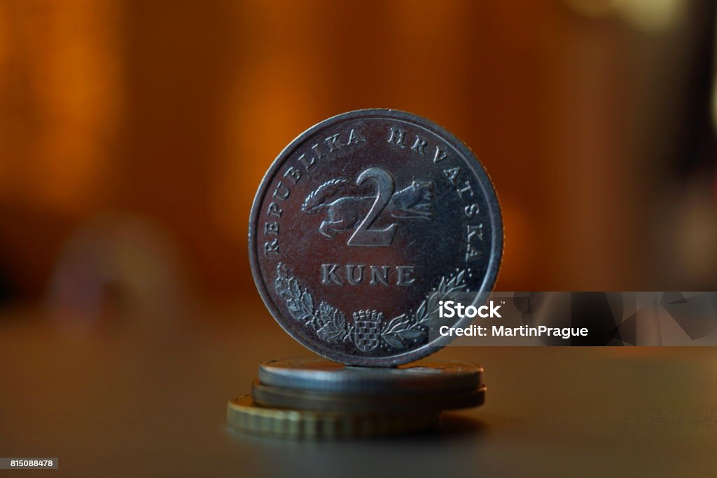 Macro detail of a metal Croatian coin (2 Kune) on the top of column created of coins with a positive colorful warm background Backgrounds Stock Photo