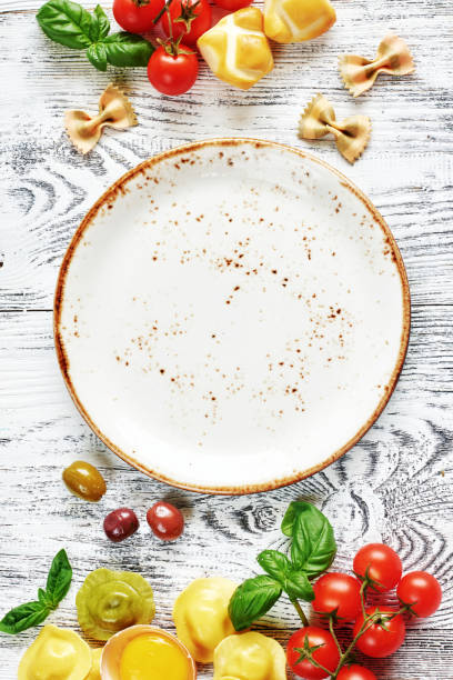 A neatly arranged stack of white ceramic plates in a professional restaurant kitchen. The monochrome aesthetic emphasizes cleanliness, organization, and efficiency in food service. The repetitive pattern and soft lighting create a minimalist yet elegant atmosphere, making this image ideal for hospitality branding, restaurant supply promotions, and kitchen management visuals.
