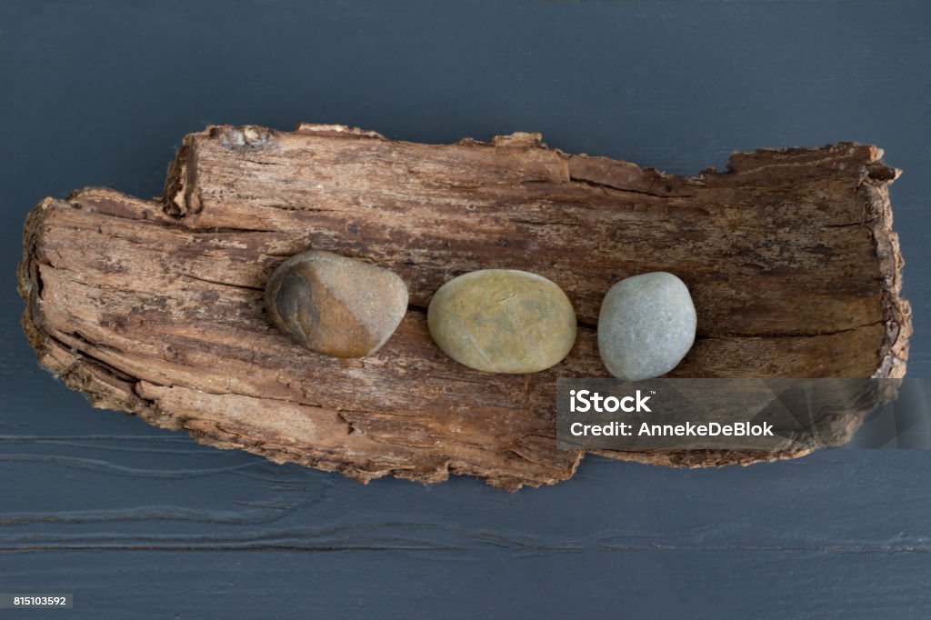 Decoration with tree bark and pebbles Decoration with brown tree bark and pebbles placed on a dark blue wooden table outdoors Creativity Stock Photo