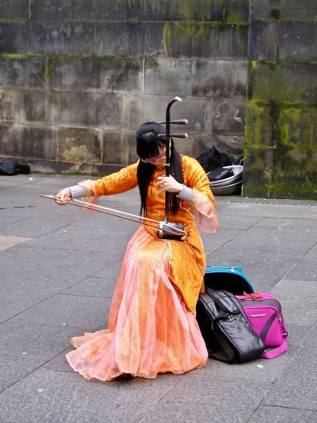 Edinburgh, Scotland, UK, August 2008.  A delightful Chinese female musician was busking in the street during the festival held at this time of year.