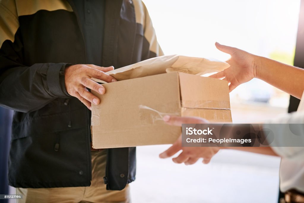 Hassle-free door-to-door delivery Shot of a courier making a delivery to a customer Delivering Stock Photo