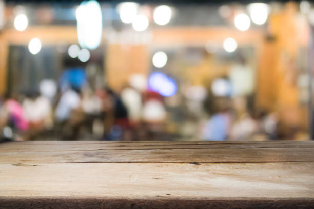 istock Empty wooden table for present product on coffee shop or soft drink bar blur background with bokeh image 815127276