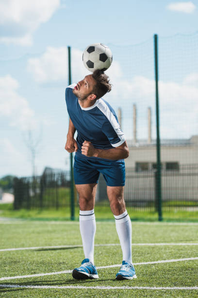istock focused soccer player training with ball on soccer pitch 815127730