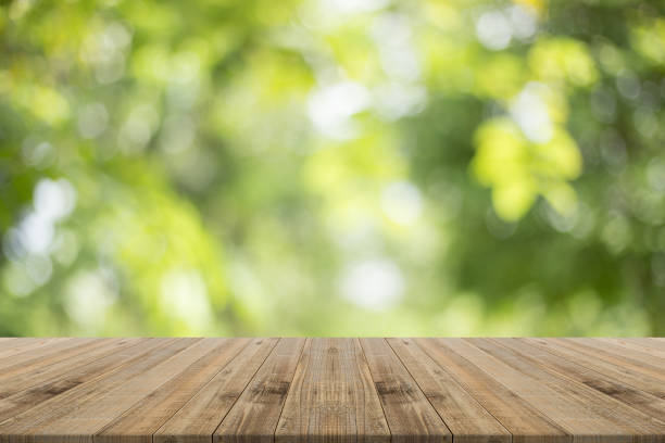 istock Wood table top on nature green blurred background 815165976