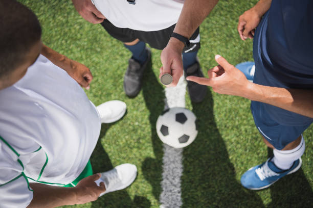 photo recadrée d’arbitre tenant la pièce avant le début du match de football sur terrain - throwing football men ball photos et images de collection