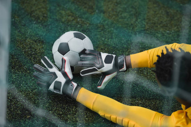 african american goalkeeper catching soccer ball during game - soccer glove imagens e fotografias de stock